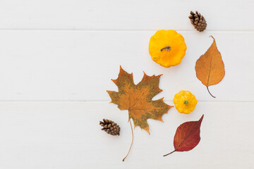 Autumn holiday frame composition with pattern made of leaf, punpkins, dried orange, pine cone on...