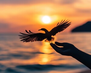 Obraz premium Silhouette of a person holding a bird in front of a sunset over a body of water - Animals