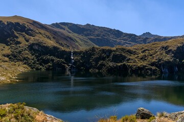 Serene mountain lake with waterfall