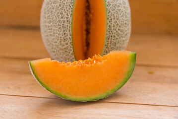 Closeup focus to split the orange melon on wood plate