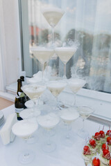a pyramid of champagne glasses in a restaurant at a wedding