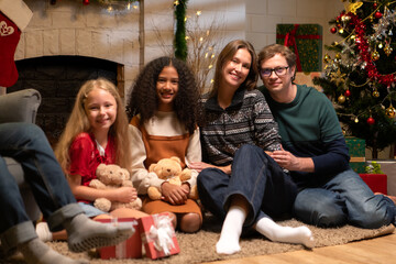 Grandfather, parents, and the teenage girls are relaxing in the living room at home on Christmas night