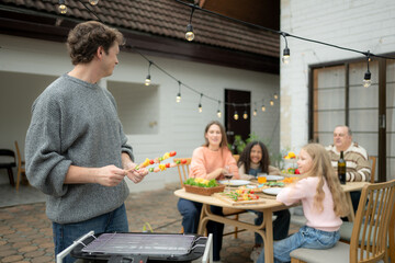 Grandfather, parents, and the teenage girls are all having dinner together at home