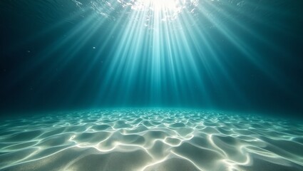 Light beams illuminating sandy sea floor underwater