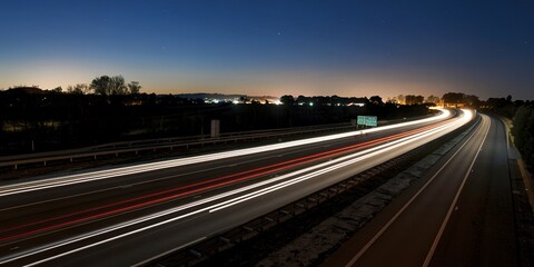 Fototapeta premium Long exposure of a highway at night with light trails from passing vehicles