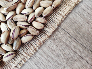 Fresh natural dried pistachios on woven jute fabric