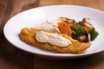 Crispy Breaded Fish Fillet With Vegetables And Creamy Sauce