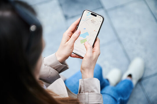 Lviv, Ukraine - October 10, 2024: close up person uses smartphone Iphone 16 Pro to navigate map application, exploring locations and planning route with real-time data. Technology, lifestyle concept.