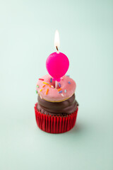 Pink Frosted Cupcake with Candle on Pastel Background
