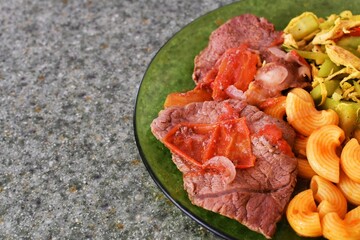 Almuerzo de carne de res con pasta y vegetales. Concepto de comida balanceada, espacio para texto al lado izquierdo.
