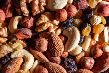 Mixed Nuts: Almonds, Walnuts, Cashews, Peanuts, Hazelnuts, Dried Prunes and Raisins. Different Nut Mix. Background from Various Nuts and Dried Fruits