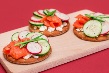 Crispy Cracker Sandwiches with Fresh Salmon, Cucumber, Radish, Cottage Cheese and Green Onions. Easy Breakfast. Quick and Healthy Sandwiches. Crispbread with Tasty Filling. Healthy Dietary Snack