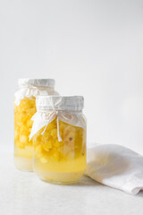 pineapple cheong in a glass jar on a white background, korean pineapple cheong in a transparent jar, pineapple in sugar syrup