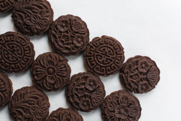 Overhead view of stamped chocolate cookies on a parchment lined baking tray, top view of embossed chocolate sugar cookies on a white background