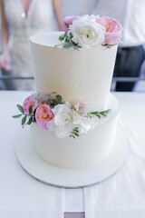 large three-tiered cake at a wedding with decor delicious beautiful
