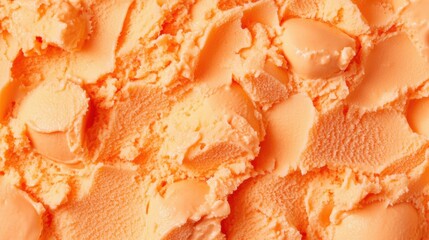A surface densely covered with scoops of bright orange sherbet, filling every inch of the frame with its creamy, cold texture and vibrant color.
