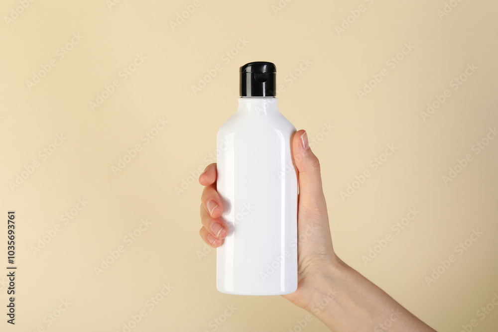 Canvas Prints Woman with shampoo bottle on beige background, closeup