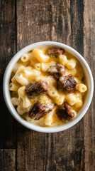 Mac and cheese with pulled pork served in a rustic white bowl on a wooden table