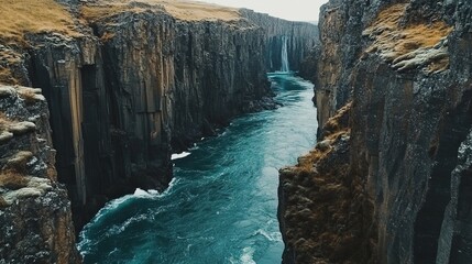 Naklejka premium A River Carving Through Icelandic Cliffs