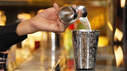 Closeup mixing hand bartender holding jigger to measure sugar salt all of ingredients into shaker preparation at bar. Special refresh drink showcasing nightlife mixology inviting warm light. Vinosity.