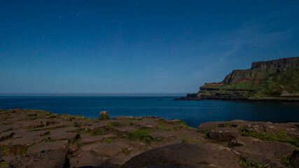 Giant's Causeway with the amphitheatre in the background under a clear night sky