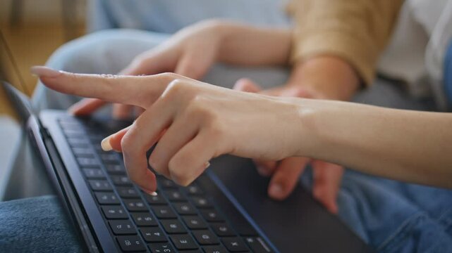Girlfriend hands pointing laptop showing something to boyfriend at home closeup.