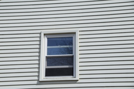 single hung window on a white siding wall open
