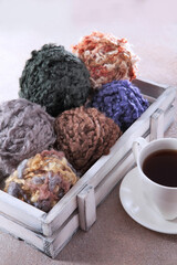 Wool yarn for knitting. A cup of coffee. Skeins of yarn for knitting as a background. Handmade work. The concept of a hobby.