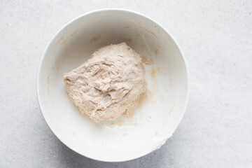 Bread dough being mixed in a ceramic bowl, Beet Focaccia dough in a white bowl, process of making pink focaccia