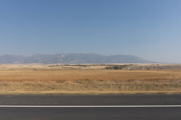Wildfire smoke over Montana Mountains, hazy road view of western fire landscape, rural Idaho climate change