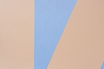 textured beige pink paper sheets on blue with a geometric blank shape between