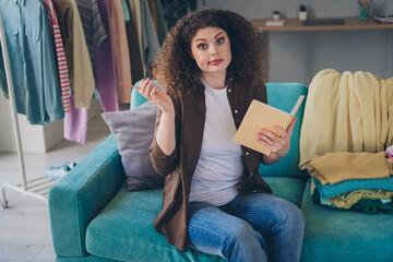 Photo of young funny woman wearing casual outfit preparing outfits for weekend shrug shoulders dont know her all clothes list