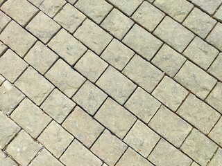 A close-up view of an intricately arranged brick pavement showcasing a textured surface under bright daylight