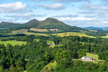 Fototapeta premium Panoramic westerly view from Scott's View near Melrose, UK over landscape near Scottish Borders, overlooking the valley of the River Tweed and the three peaks of the Eildon Hills