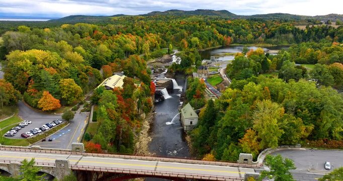 Flight above the arch bridge approaching the waterfalls in Ausable Chasm in Adirondacks. Beautiful forest changing colors in autumn around.