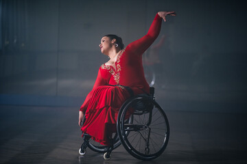 Woman with a disability, a para dancer practicing choreography at the dance studio, making...