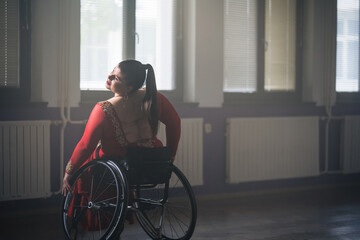 Female wheelchair dancer performing beautiful elegant choreography at a dance studio. Disability sport concept.