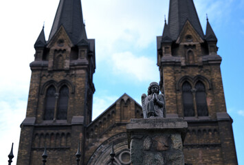 A close-up of an angel sculpture on the stone fence of St. Nicholas Church against the backdrop of the blue sky in the city of Kamianske, Ukraine