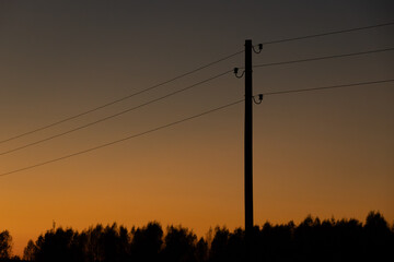 A minimalist scene featuring a power line silhouette with trees in the distance, set against a...