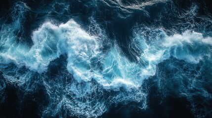 Aerial view of turbulent ocean waves crashing with intense energy, creating a stunning pattern of white foam.
