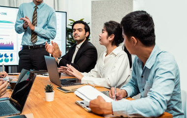 Fototapeta premium Group of happy multi ethnic businesspeople in celebratory gesture and successful teamwork after made success sales or positive financial data dashboard display on screen in meeting room. Habiliment