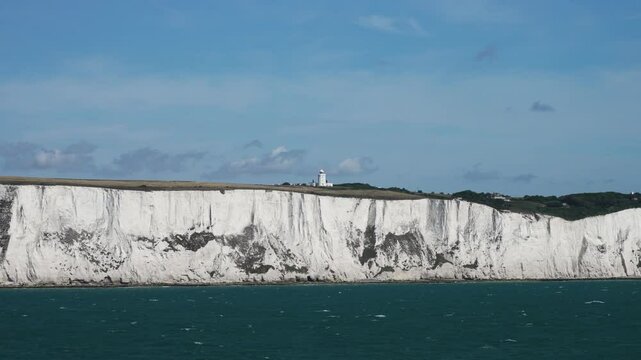 View From Ferry Showcasing Iconic White Chalk Cliffs Near Dover, England, With Serene Sea Reflecting Sky. Panning View Along English Coastline of White Chalk Cliffs with Fields and Calm Sea on