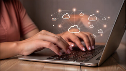 Hands typing on a laptop with cloud technology graphics in an indoor setting
