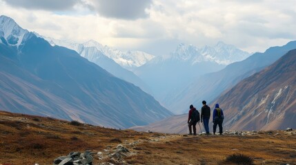 Obraz premium Hikers admiring breathtaking snowy mountain range landscape, concept of adventure travel, exploration and freedom in nature.