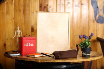 This image features a blank chalkboard placed on a minimalist workspace. A wooden mannequin,...