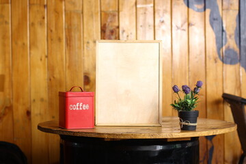 This image features a blank chalkboard placed on a minimalist workspace. A wooden mannequin,...