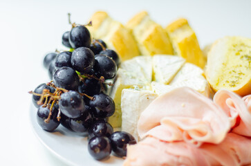 A plate of food with bread, cheese, and grapes
