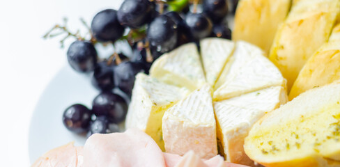 A plate of food with bread, cheese, and grapes