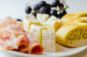 A plate of food with bread, cheese, and grapes