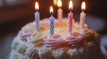 A beautifully decorated birthday cake with lit candles and rose icing details.